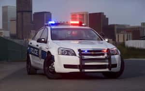 警車在黃昏時分停泊在城市中，燈光閃爍。 — 警察 GIF 壁紙