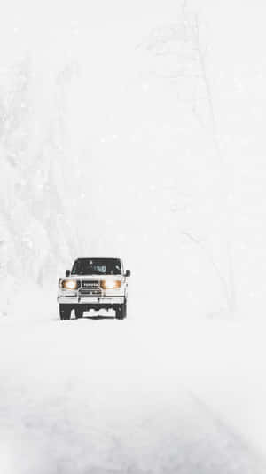 白色貨車在冬季森林的猛烈暴風雪中行駛。 — 冬季風景 壁紙