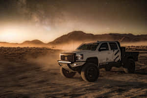 白色越野車在星空下的沙漠夜間行駛。 — Gmc 壁紙
