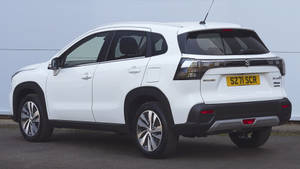 白色鈴木 S-Cross SUV 停放在波紋牆前。 — 鈴木 壁紙