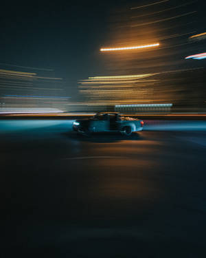 一輛皮卡車在夜晚霓虹燈閃爍的城市街道上疾馳。 — 汽車 iPhone 壁紙
