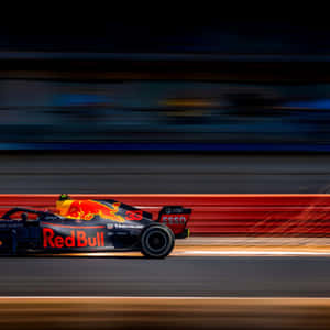 紅牛F1賽車在日落時分的賽道上以動態模糊高速行駛。 — iPad Air 11 壁紙