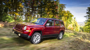 紅色Jeep Patriot在秋季森林小徑上行駛。 — 吉普 壁紙