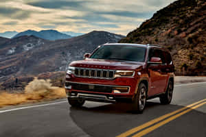 紅色Jeep Wagoneer在覆蓋積雪的山路上行駛 — MacBook Air 13 壁紙