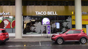 夜晚Taco Bell餐廳外停放的紅色SUV和濕漉漉的人行道。 — 塔可 壁紙