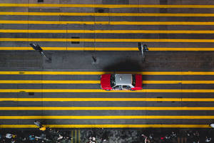 紅色和銀色計程車從上方穿越黃色條紋的城市街道。 — 香港 壁紙
