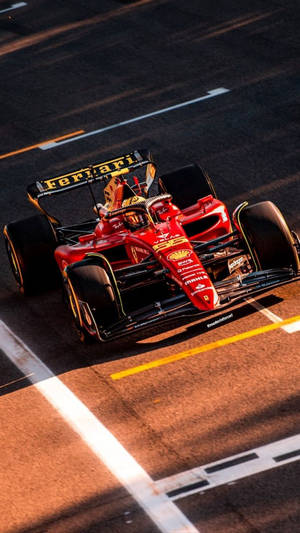 紅色法拉利F1賽車在日落時分的賽道上飛馳。 — 賽車 壁紙