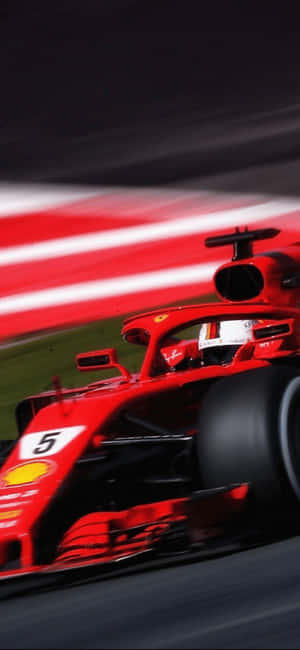 紅色法拉利F1賽車在夜間賽道上行駛，帶有動態模糊效果。 — iPhone 14 Pro Max 壁紙