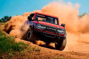 紅色福特 Bronco Raptor 爬泥土山坡揚起塵土 — 福特 壁紙