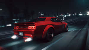 紅色肌肉車在夜間穿過城市，排氣管火焰發光。 — 超跑 壁紙