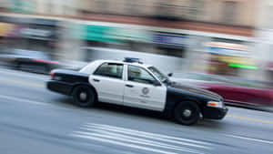 紐約警察局警車在模糊背景的城市街道上高速行駛。 — 皇冠 壁紙