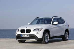 白色BMW X1 SUV停泊在海濱，背景有橋樑。 — Mercedes Benz C300 壁紙