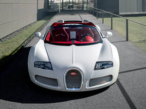 白色Bugatti敞篷車，紅色座椅，停放在現代化車道上。 — Bugatti iPhone 壁紙