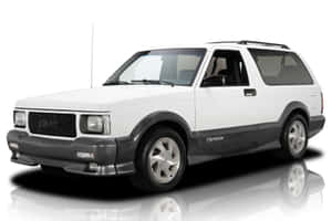 白色GMC Typhoon SUV，帶有黑色飾邊和銀色輪圈，在反射的攝影棚地板上。 — 低飽和 壁紙