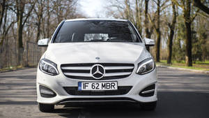 白色賓士汽車在日光下停泊在樹蔭大道上。 — Mercedes Benz C300 壁紙
