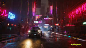 一輛汽車在夜晚穿過一條霓虹燈閃爍、潮濕的賽博朋克城市街道。 — 電馭叛客2077 壁紙