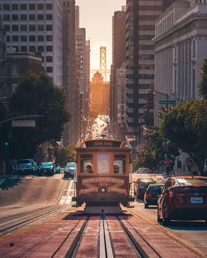 日落時分，纜車在范尼斯大道上，背景是金門大橋。
