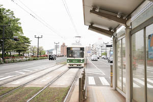 綠色和白色的電車抵達現代化的城市車站月台。 — 火車 壁紙