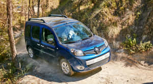 藍色雷諾Kangoo Trekking在森林中的泥路上行駛。 — 雷諾 壁紙