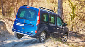 藍色雷諾Kangoo廂型車在樹林地區的泥土坡上行駛。 — 雷諾 壁紙