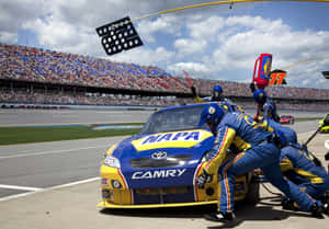 NASCAR維修站人員在比賽期間為藍黃色的豐田Camry賽車更換輪胎。 — 賽車 壁紙