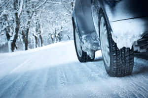 冬日道路上被雪覆蓋的汽車，背景是積雪的樹木。 — MacBook Pro M3 壁紙