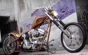 訂製chopper摩托車，生鏽車架和鍍鉻引擎，停靠在塗鴉牆邊。 — 巴布風機車 壁紙
