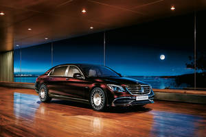 室內棗紅色豪華轎車，透過玻璃牆欣賞月光下的海濱景色。 — Mercedes Benz C300 壁紙