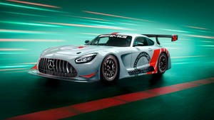 銀色 Mercedes-AMG GT3 賽車在賽道上以青綠色和紅色動態模糊效果疾馳。 — Mercedes Benz C300 壁紙