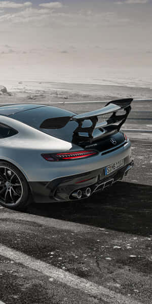 銀色 Mercedes-AMG GT R 跑車停泊在雪路上，黃昏時分。 — 18:9 壁紙