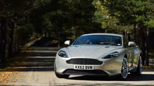 銀色Aston Martin在秋天的森林道路上行駛。 — 奧斯頓馬丁 壁紙