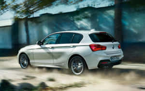 銀色BMW掀背車在塵土飛揚的道路上高速行駛，帶有動態模糊效果。 — Steam Deck OLED 壁紙