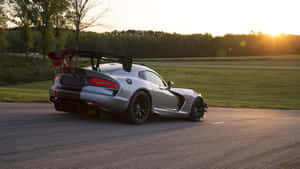 日落時分賽道上的銀色Dodge Viper GT3-R跑車與金色光芒。 — 道奇挑戰者 壁紙