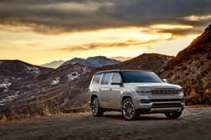 銀色Jeep Grand Wagoneer在日落時分停泊在山路上。 — 老福特卡車 壁紙