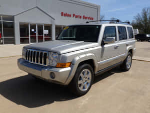 陽光明媚的日子裡，一輛銀色Jeep Liberty SUV停放在汽車經銷商處。 — 吉普 壁紙