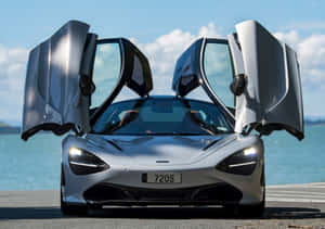 銀色McLaren 720S，鷗翼車門打開，停在海邊。 — 水 壁紙