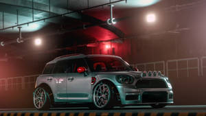 銀色MINI Cooper，帶有紅色點綴，停在光線昏暗的工業車庫中。