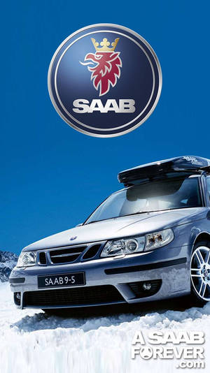 雪地上的銀色Saab 9-5旅行車，上方有Saab標誌。 — 紳寶 壁紙