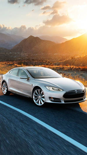 銀色Tesla Model S在金色日落時分行駛在沙漠公路上。 — 特斯拉 壁紙