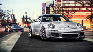 銀色保時捷911 GT3 RS停泊在日落時分的城市街道上。 — 保時捷 911 壁紙