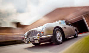 銀色經典Aston Martin在磚砌隧道中疾馳，帶有動態模糊效果。 — 奧斯頓馬丁 壁紙