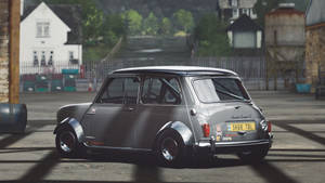銀色經典Mini Cooper S賽車在工業庭院中，背景有石建築物和綠色植物。 — 極限競速 地平線 4 壁紙