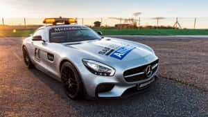 銀色賓士AMG GT安全車在賽車場上閃爍著警示燈，日落時分。 — 賽車 壁紙