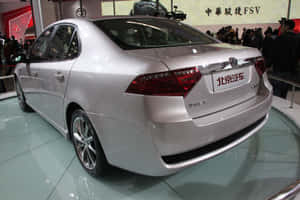 銀色轎車在車展上展出，背景有群眾。 — 3:2 壁紙