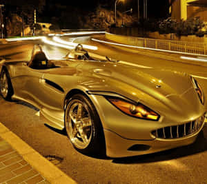 金色跑車夜間停泊在濕滑街道上，帶有光軌。 — 汽車 壁紙