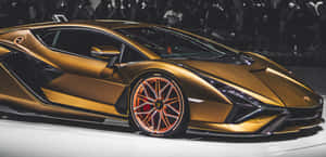金色藍寶堅尼跑車展示，搭配橙色輪胎，背景模糊人群。 — 金色動態 壁紙