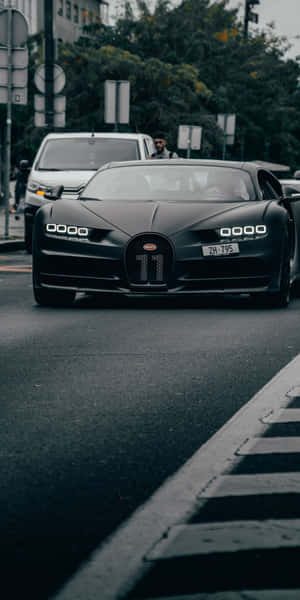 黑色Bugatti Chiron，水箱護罩上有11號，在城市街道上行駛。 — 豪華車 壁紙