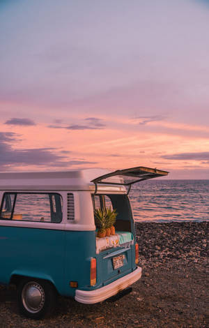 復古青綠色露營車停在沙灘上，有鳳梨，夕陽西下。 — 海灘 壁紙