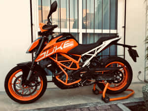 橙色和黑色的KTM 390 Duke機車停放在磁磚庭院上。 — 橘色 壁紙
