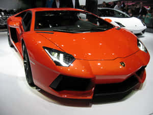橙色藍寶堅尼Aventador在車展上展出，後面有群眾。 — 跑車 壁紙